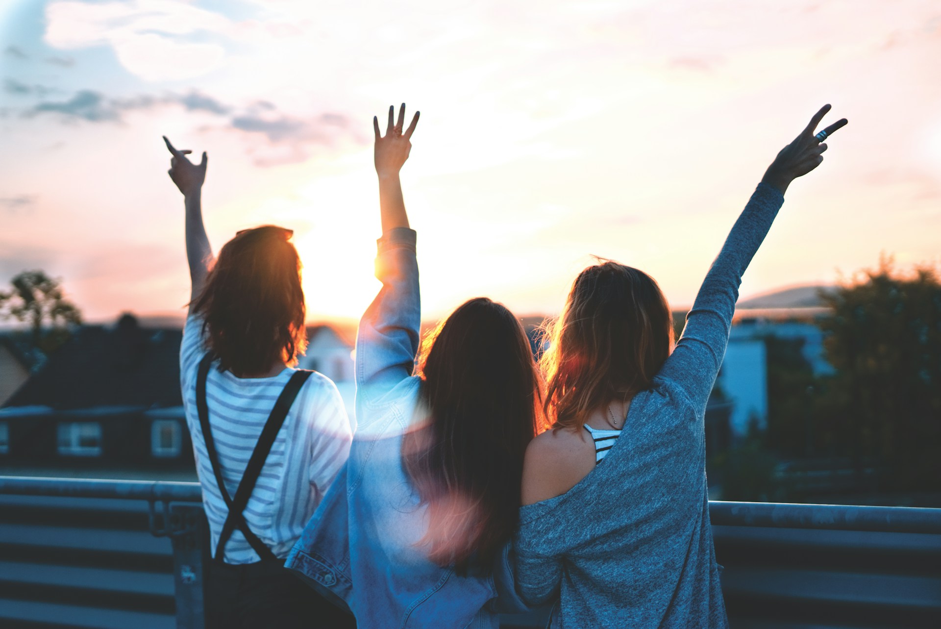 3 friends lifting their hands